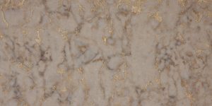 Close-up of a quartz slab features gold and brown veins swirling atop a creamy tan background.